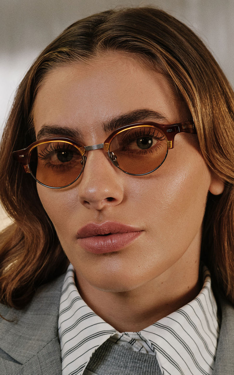 Mulher com óculos de grau com armação marrom e lentes âmbar 