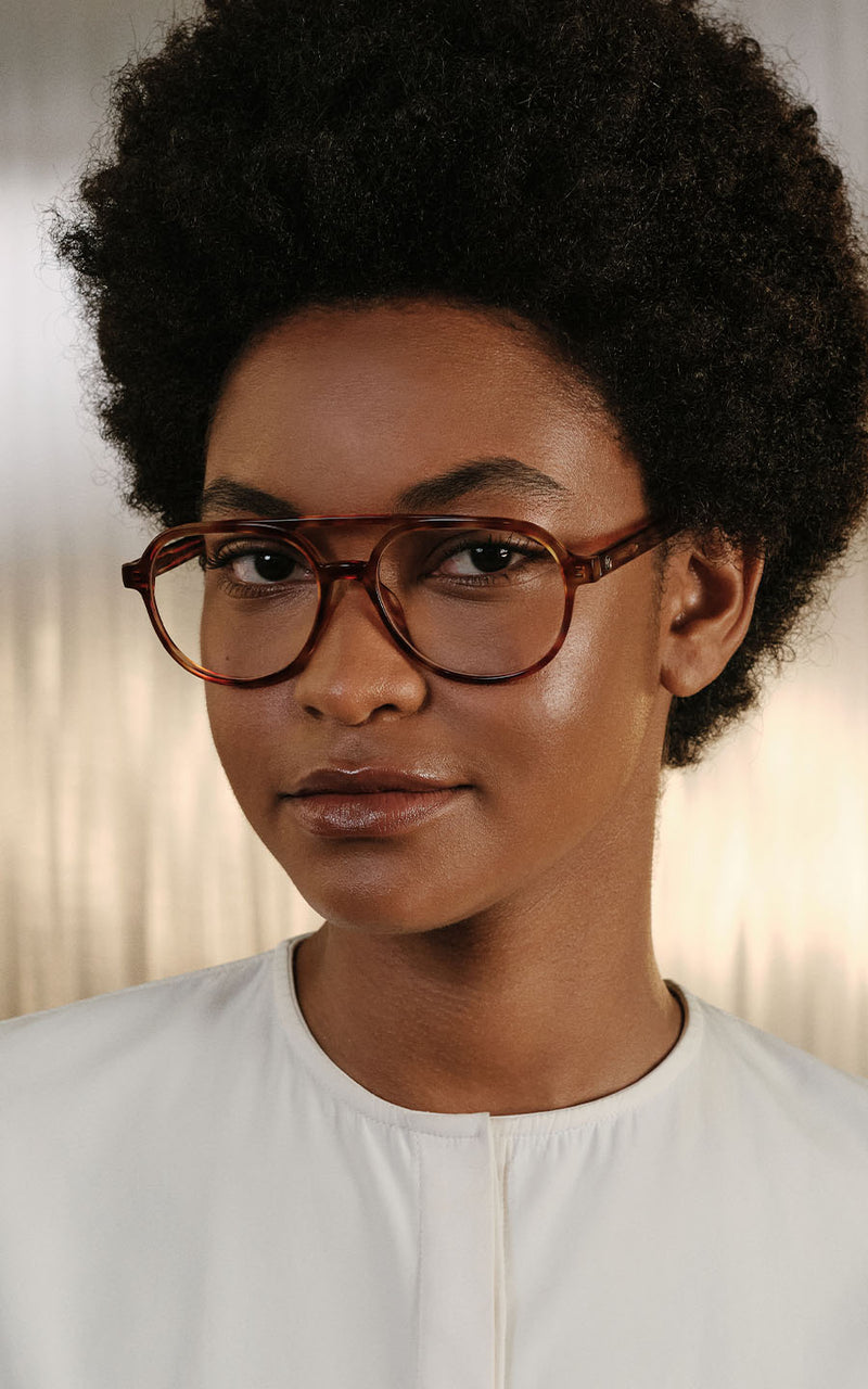 Mulher usando óculos de grau com armação marrom
