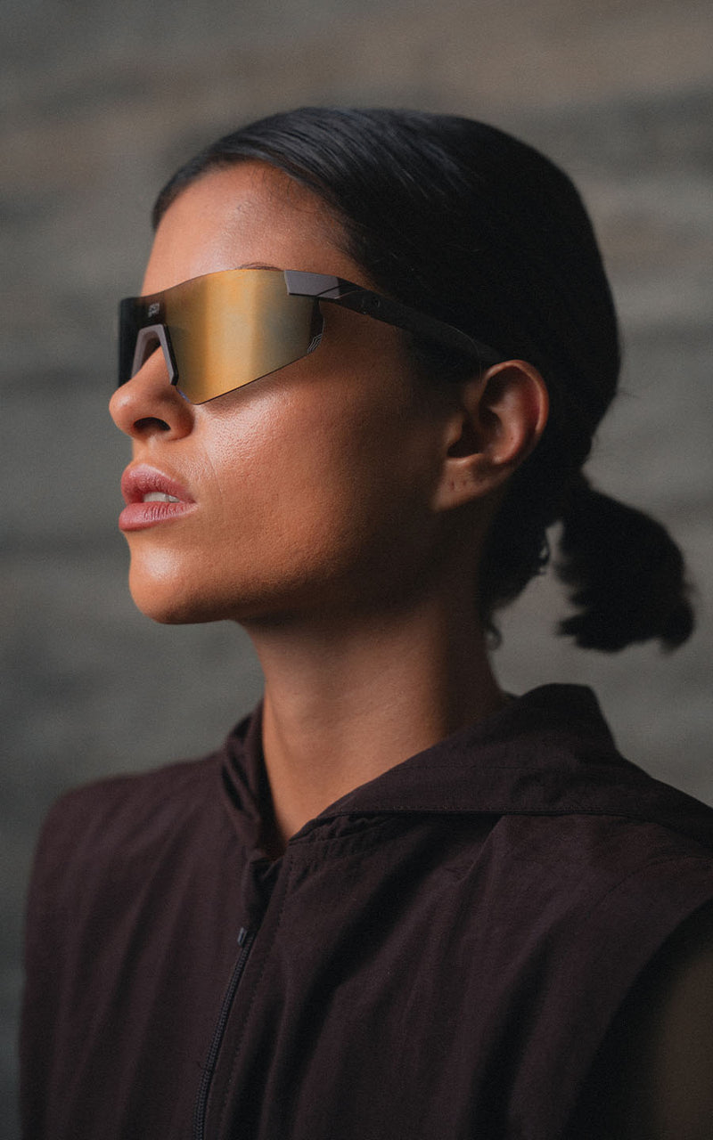 Mulher usando óculos de sol esportivos com lentes espelhadas