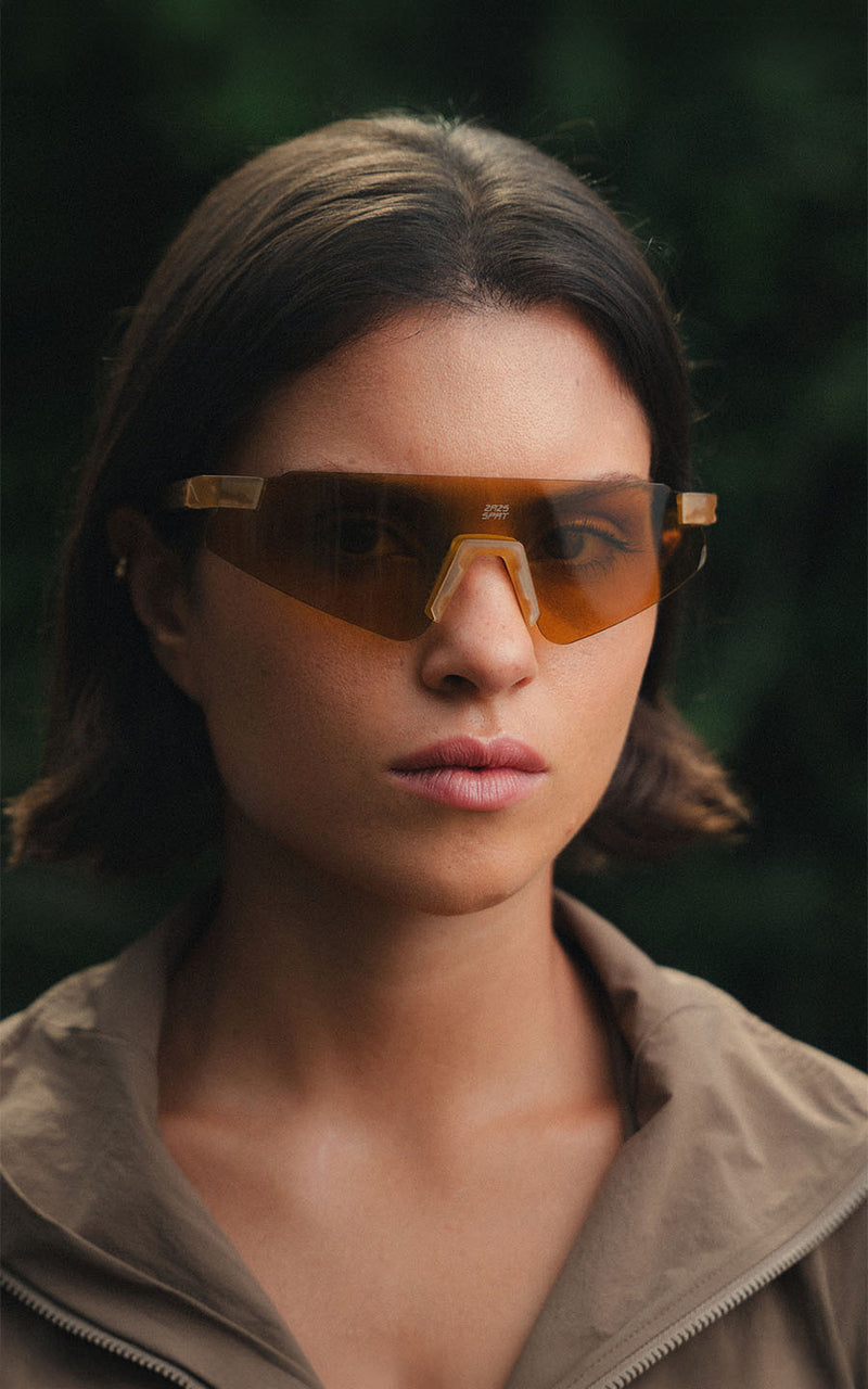 Mulher usando óculos de sol esportivos com lentes âmbar ao ar livre