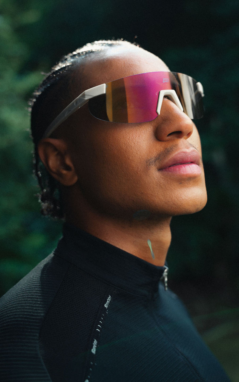 Homem usando óculos de sol esportivos com lentes espelhadas e armação branca ao ar livre