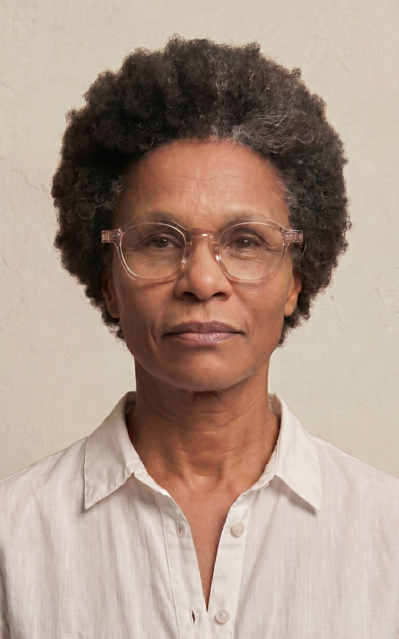 Mulher com óculos de grau com armação clara e camisa branca 