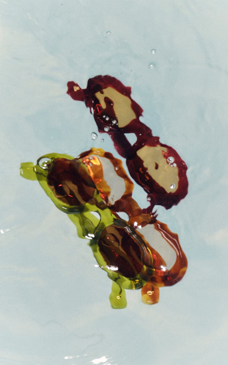 Reflexos distorcidos de óculos de sol coloridos na água