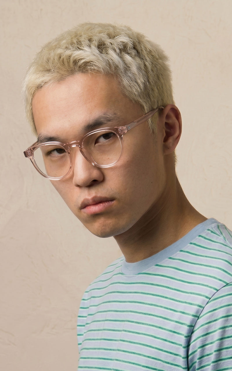 Jovem usando óculos de armação transparente e blusa listrada